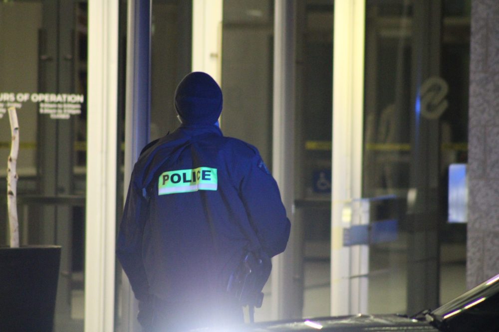 GREG VANDERMEULEN THE CARILLON
An RCMP officer keeps watch outside Steinbach Credit Union as a colleague searches the interior.