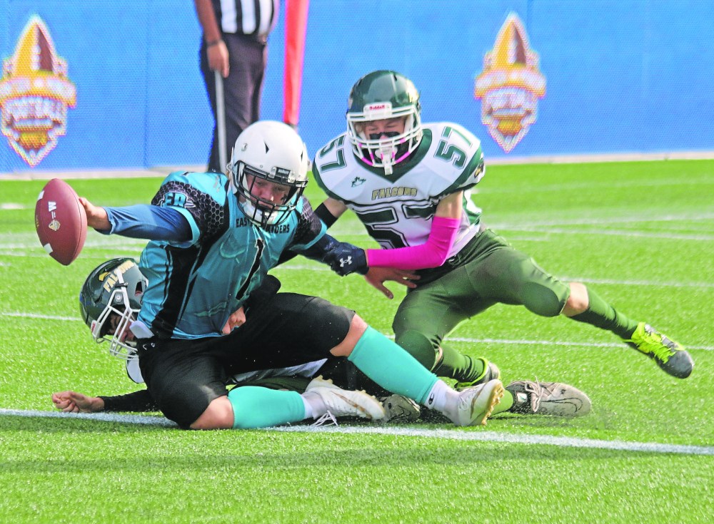 Eastman Raiders quarterback Elias Kaethler shirks off a pair of Falcons tacklers to reach the ball over the goal-line for one of his many touchdowns in the Manitoba Minor Football Association U16 final. (Cassidy Dankochik The Carillon)