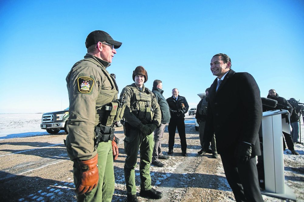 MIKAELA MACKENZIE WINNIPEG FREE PRESS
Premier Wab Kinew chats with conservation officers Nick Woroniuk (left) and Jesse Jones after making an announcement about conservation officers patrolling the border during a press conference close to the Canada-US border west of Emerson on Monday, Jan. 27, 2025.