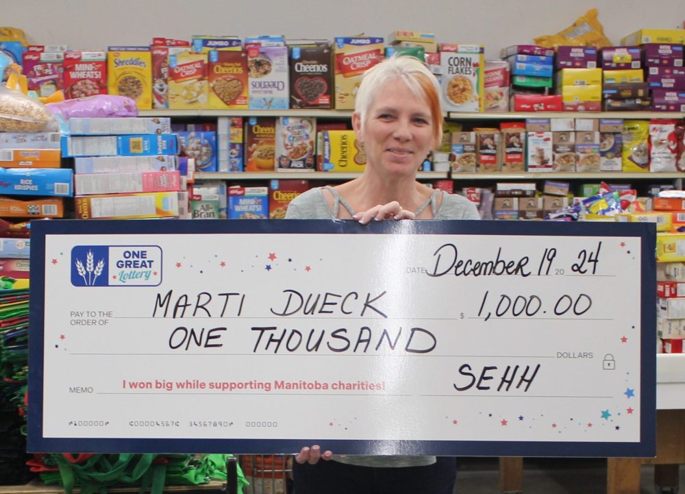 KANE CHOQUETTE THE CARILLON
Weeks after three friends from Mitchell and Landmark won nearly $4,000 in One Great Lottery, another local ticket buyer cashed in. Marti Dueck won $1,000 and was presented with the oversize cheque at South East Helping Hands on Dec. 19. Dueck, who won the prize on her birthday admitted she initially thought the phone call was a scam, but was happy to realize it was in fact true. South East Helping Hands is one of 55 charities that ticket buyers can support through the lottery. The lottery raised over $2 million in the last couple of years.