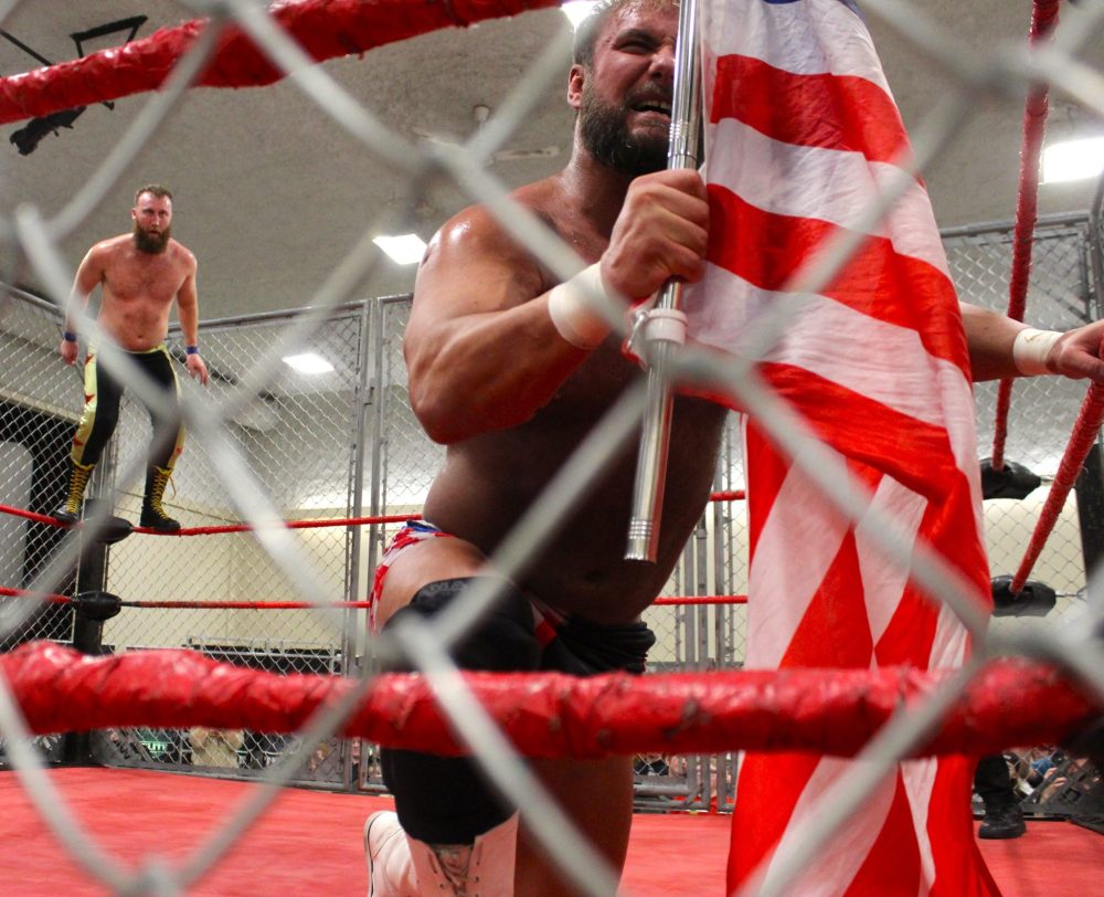 CHRIS GAREAU THE CARILLON
Red Hot Sammy Peppers climbs the top rope as Hot Shot Danny Duggan reaches for his American flag’s pole. Despite Duggan’s shenanigans, Peppers won Canadian Wrestling Elite’s first cage match held in Steinbach Feb. 1 in front of a packed crowed in the Pat Porter Centre.
