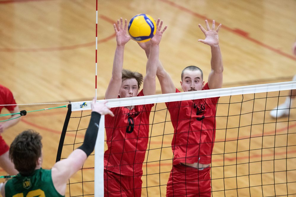 BROOK JONES/FREE PRESS
The University of Winnipeg Wesmen play host to the Canada West Men's Volleyball Championship gold medal game for the first time in their program history at the Duckworth Centre in Winnipeg, Man., Saturday, March 8, 2025. The No. 1 seeded U of W Wesmen won the CanWest championship title against the No. 2 seeded Univesity of Alberta Golden Bears 3-0 (25-20, 25-20, 25-21). Pictured: U of W Wesmen middle Easton Dick spikes the ball as U of A Golden Bears outside Isaac Heslinga (left) and middle Owen Harris (right) go up for the block during first set action.