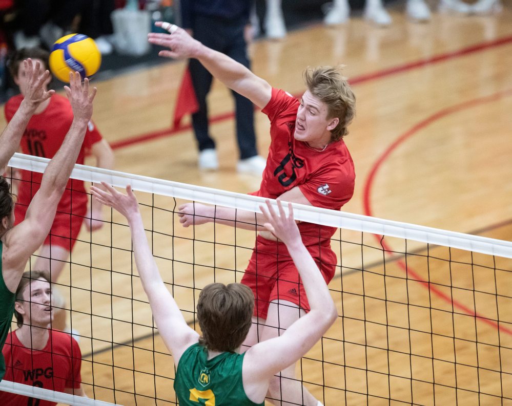 BROOK JONES/FREE PRESS
U of W Wesmen middle Easton Dick spikes the ball as U of A Golden Bears outside Isaac Heslinga (left) and middle Owen Harris (right) go up for the block during first set action in the CanadaWest final.