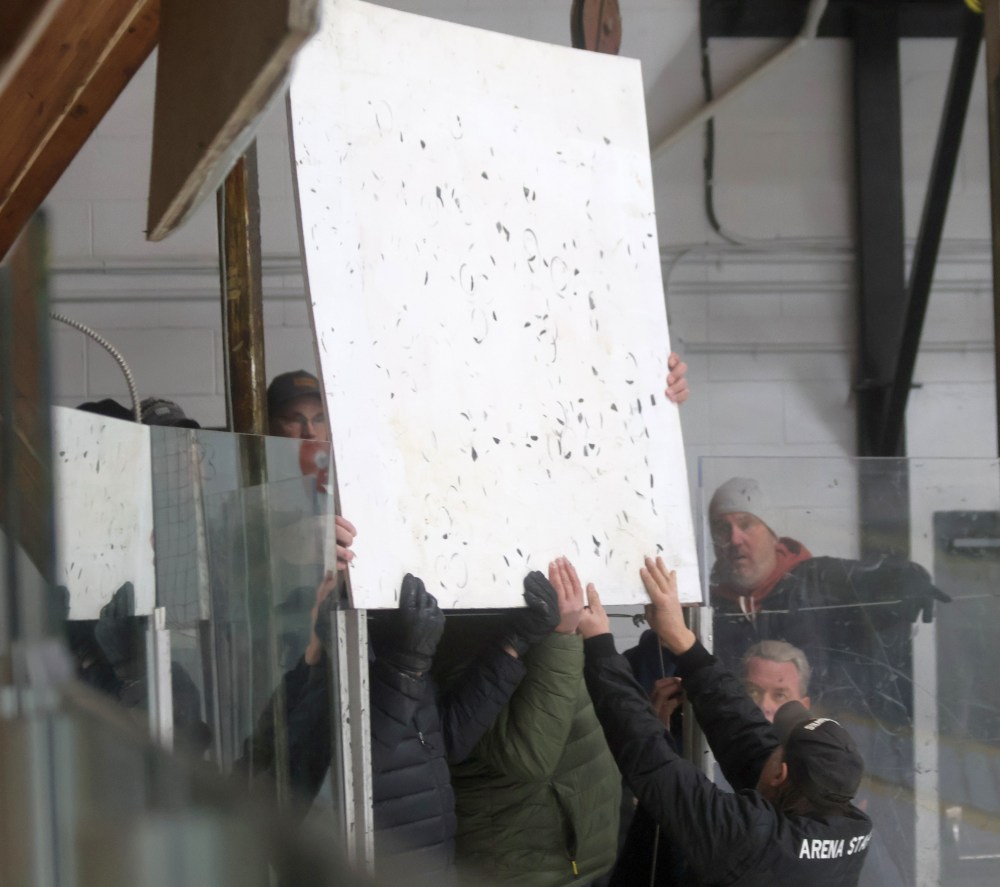 It took a group effort to replace a pane of glass mid-way through the second period of game two in the South East Manitoba Hockey League finals. (Cassidy Dankochik The Carillon)