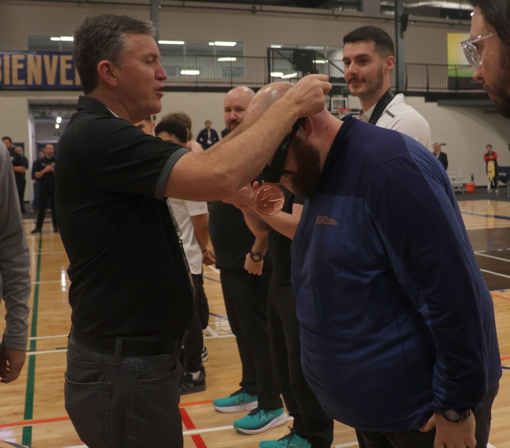 Niverville Mayor Myron Dyck presents bronze medals to the College of the Rockies Avalanche. Dyck was on hand to present medals to the top teams at the CCAA national championships. (Cassidy Dankochik The Carillon)