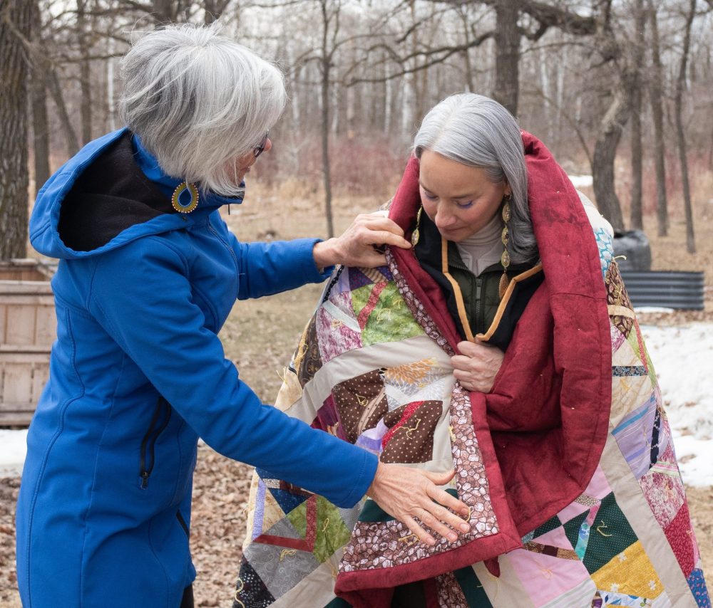 SVJETLANA MLINAREVIC THE CARILLON
Minister of Families Nahanni Fontaine visited the El'dad Ranch in Steinbach on Tuesday April 1, 2025, to see firsthand the work that the agency is doing. Here MCC Manitoba board chair Janet Plenert finished wrapping a ceremonial blanket around Fontaine's shoulders. El'dad helps residents with intellectual disabilities who are part of the alternative justice program and those who are in the day program learn life skills and get employment.