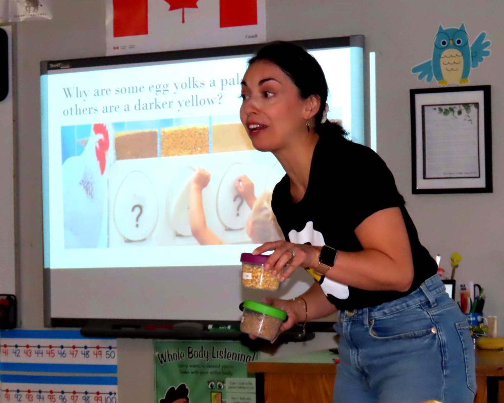 WES KEATING THE CARILLON
Displaying a couple of containers of chicken feed, an animated MEF marketing manager Adriana Findlay explains to a grade two class why some egg yolks are darker yellow than others.