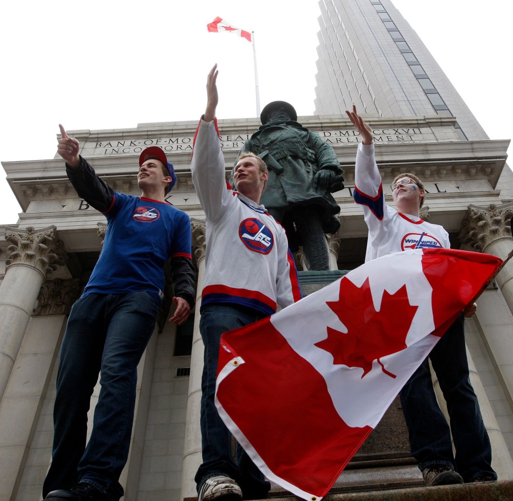 KEN GIGLIOTTI / WINNIPEG FREE PRESS
CarillonSports editor Cassidy Dankochik (right with flag) was one of the first to arrive at Portage and Main the day True North Sports and Entertainment announced they acquired the Atlanta Thrashers and brought the NHL back to Winnipeg.
