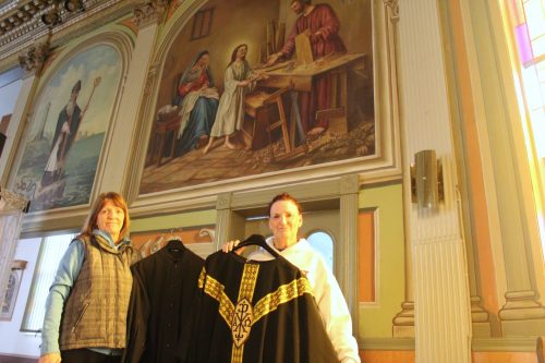 CHRIS GAREAU THE CARILLON
Lucille Brunette and her sister Colette Rozière with some antique vestments in front of one of the relatively newer paintings in Notre-Dame-de-Lorette by parishioner Noel Gauthier from 1948 depicting a young Jesus, Mary and Joseph.