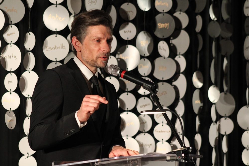 GREG VANDERMEULEN THE CARILLON
Executive Director David Klassen speaks in front of hundreds of small discs, each displaying a name of an arts centre participant.