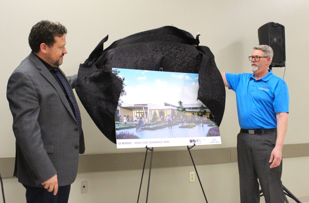 CHRIS GAREAU THE CARILLON
Minister of Municipal and Northern Relations and Minister responsible for Francophone Affairs Glen Simard unveils an illustration for the entrance of the planned Rendez-Vous community, cultural and recreational campus in St Pierre with Mayor Raymond Simard May 15.