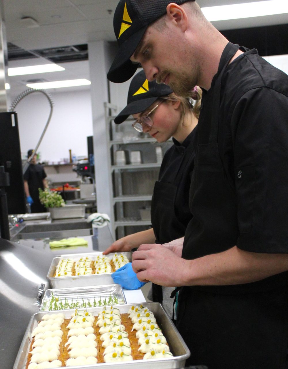 CHRIS GAREAU THE CARILLON
Each piece of carrot cake gets its own daisy flower placed on it by one of the 15 kitchen staff preparing five-course meals for over 600 guests at the Taste of Steinbach May 27.