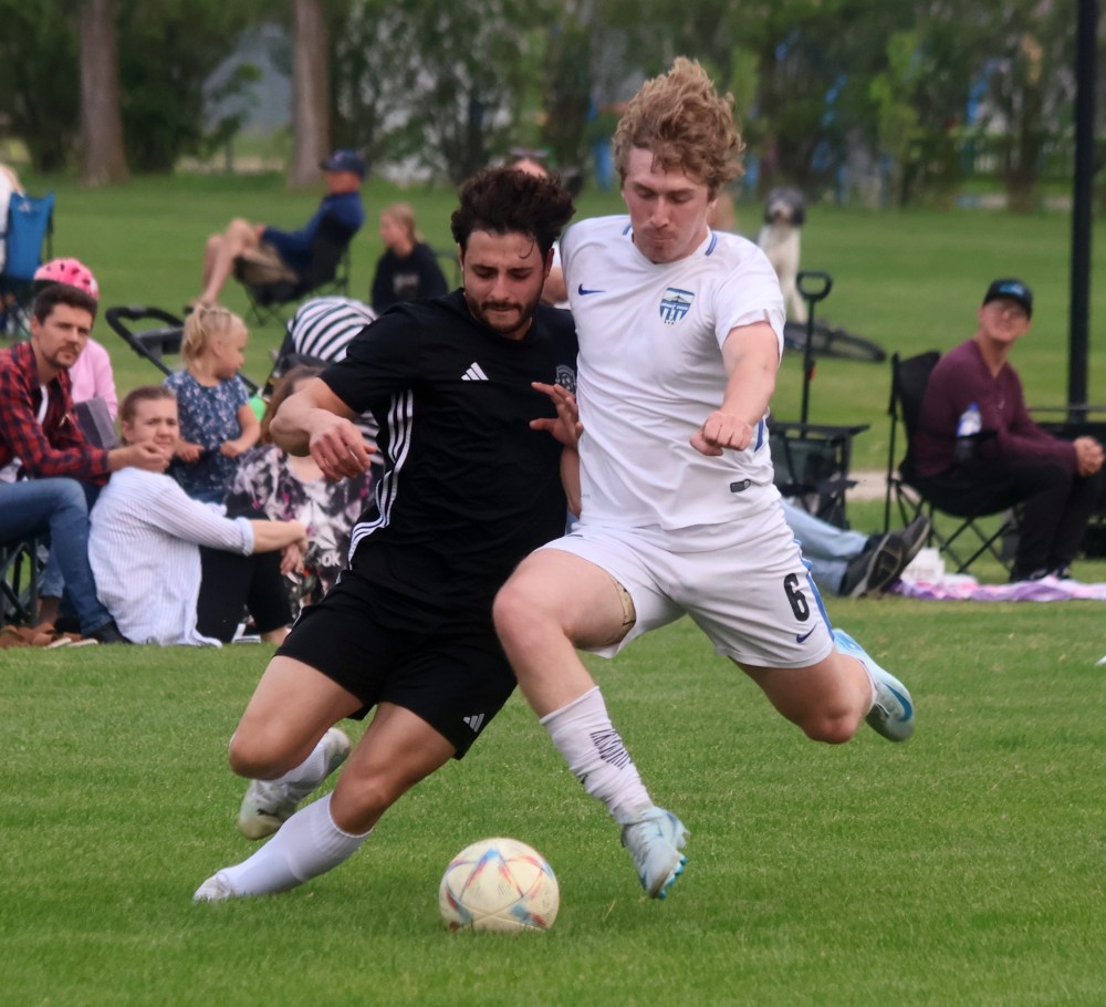 A Grant Park Sporting Club player (white) knocks the ball away from a Niverville Force player during MMSL Division One action at Niverville June 12. (Cassidy Dankochik The Carillon)