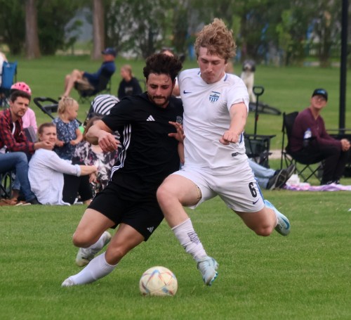 A Grant Park Sporting Club player (white) knocks the ball away from a Niverville Force player during MMSL Division One action at Niverville June 12. (Cassidy Dankochik The Carillon)