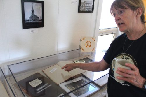 CHRIS GAREAU THE CARILLON
Parish committee member Lucille Brunette points to original baptismal and death records that date as far back as 1877. They were part of the display for the parish's anniversary events on June 21-22.