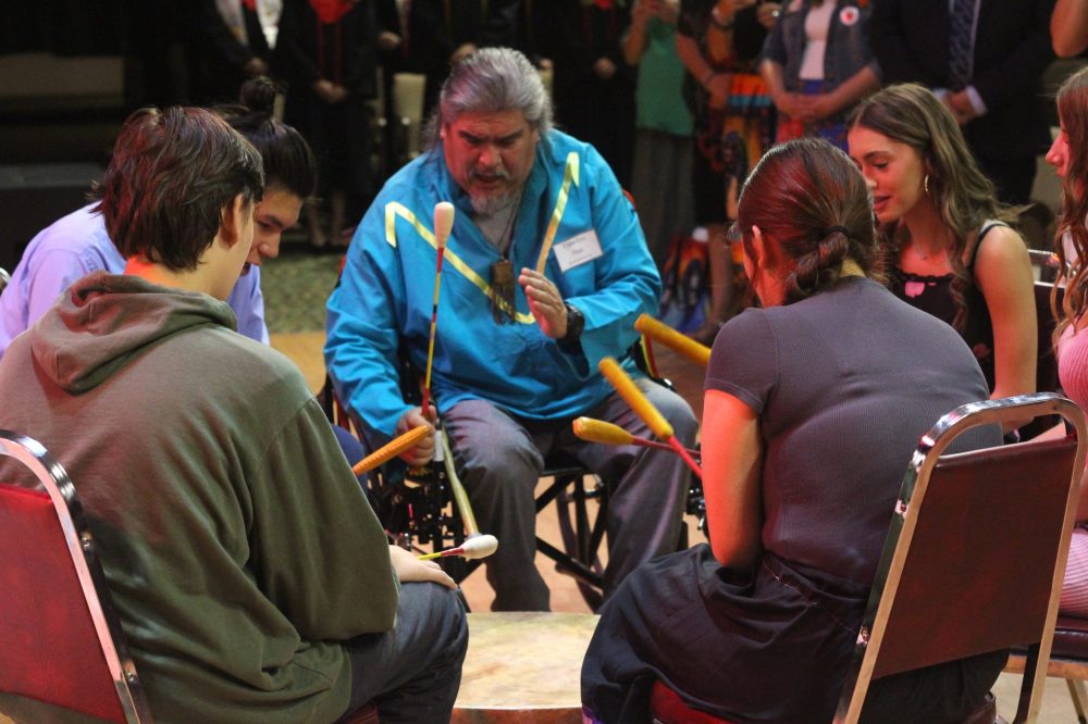 TONI DE GUZMAN THE CARILLON
Elder Eric Flett (middle) plays the drums while the audience stands up during the ceremony.