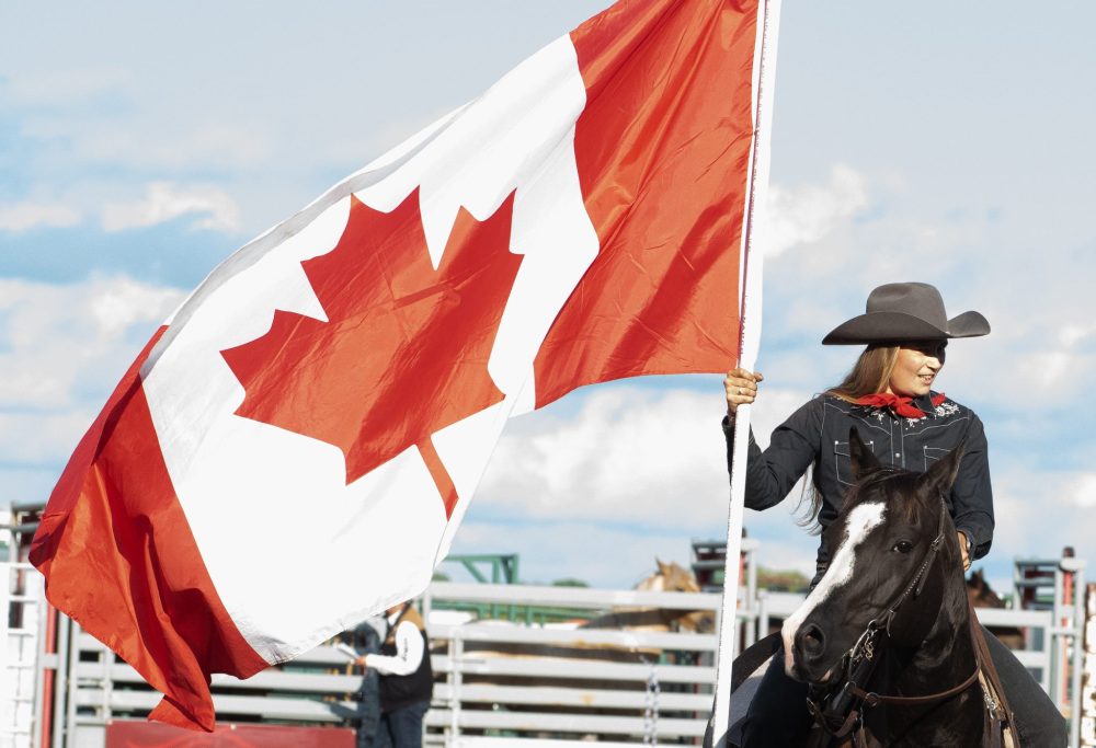 SVJETLANA MLINAREVIC THE CARILLON
A rider holds the Canadian flag during the opening ceremony for the first day of the Manitoba Stampede in Morris on July 18, 2025.