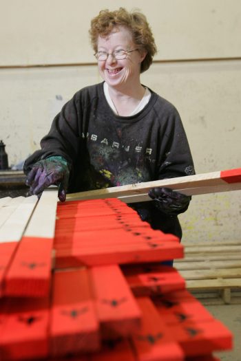 MARIANNE HELM WINNIPEG FREE PRESS ARCHIVES 

In a 2004 photo, Diane Friesen smiles as her co-workers tease her for getting her photo taken at Kindale Industries in Steinbach.