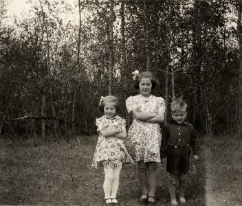 Rosengard children sheltered from the wind by woodland trees, ca 1948.