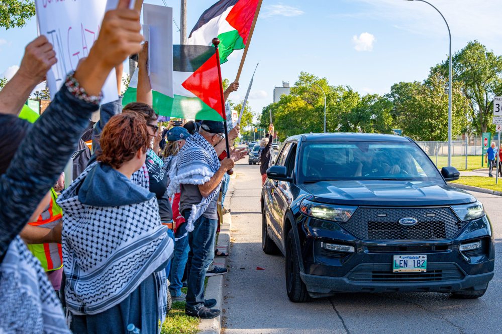 NIC ADAM / FREE PRESS
Protesters for Palestine yell shame at WPS after blocking the group with cruisers across the street from the Israel pavilion at Folklorama at the Asper Jewish Community Campus Wednesday.