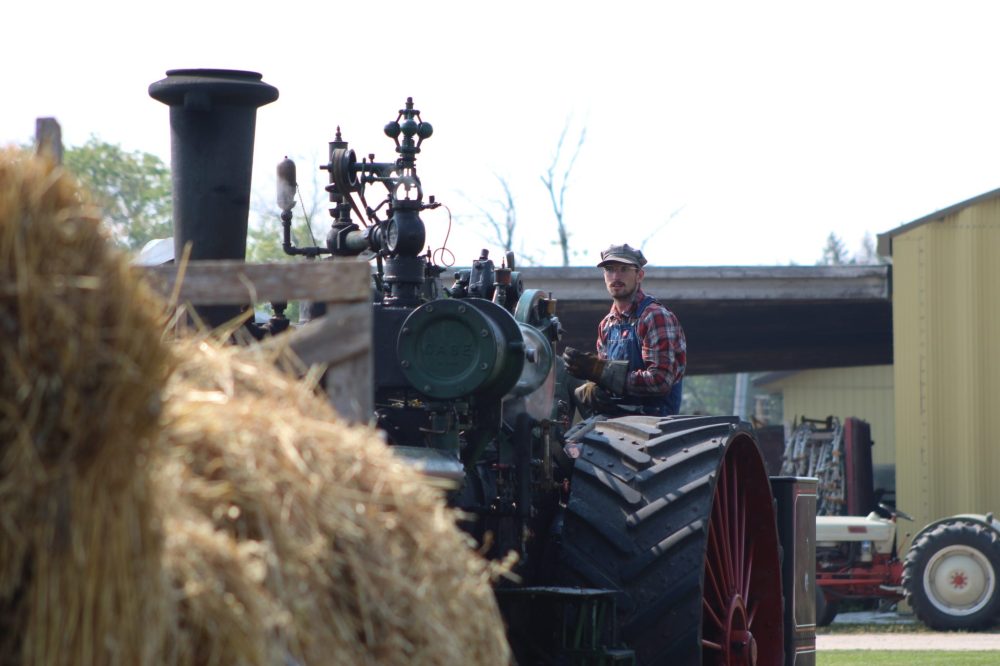 MATTHEW FRANK THE CARILLON
Dylan Peters watches the threshing from his seat on the steam engine.