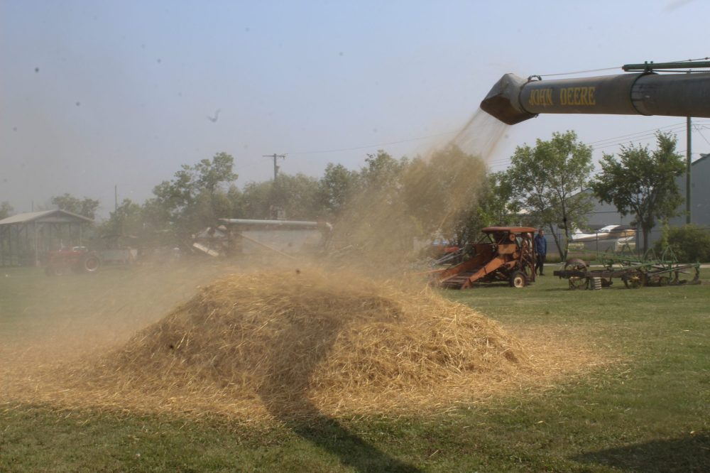 MATTHEW FRANK THE CARILLON
Chaff shoots out of the threshing machine while it works.