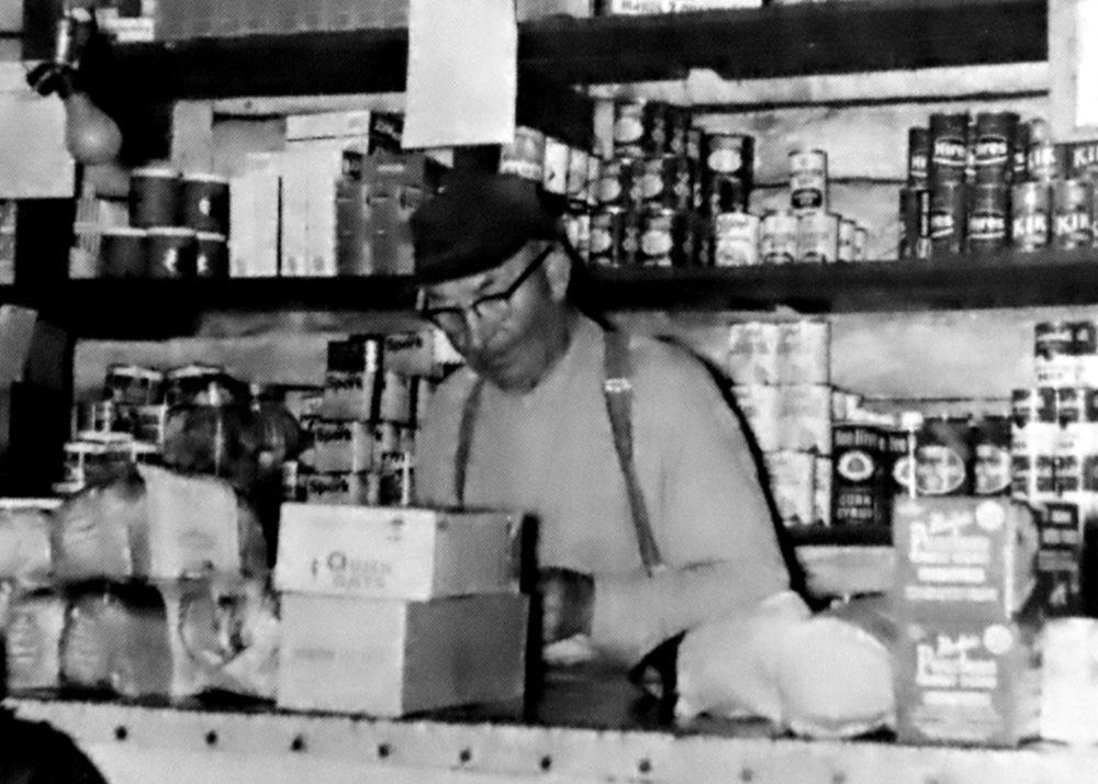 CARILLON ARCHIVES
William Nebbs gets an order ready on the counter of his old log trading post on the north shore of Indian Bay.