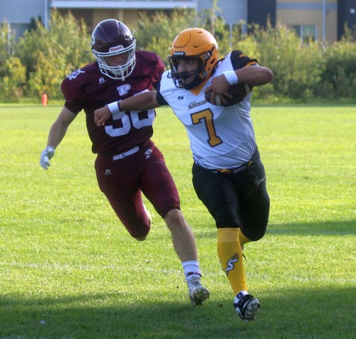 Quarterback Angelo Stoyanov outruns a St Paul's defender. (Cassidy Dankochik The Carillon)