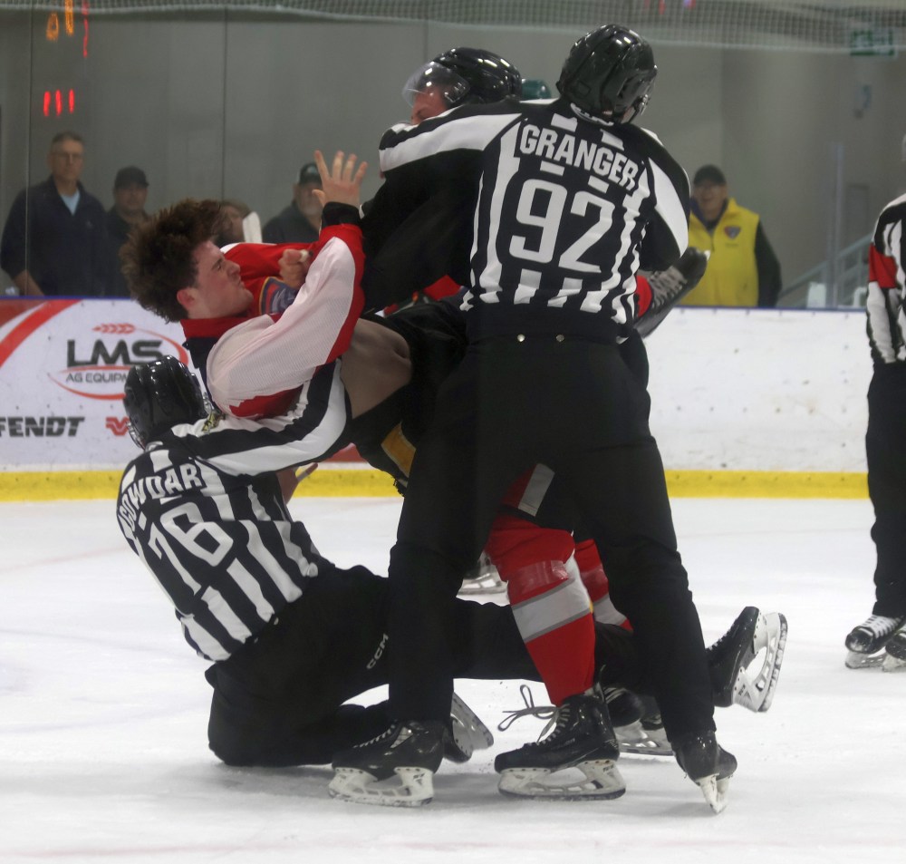 Linesmen Matt Granger and Deven Gowdar break up a fight between a Selkirk and Niverville player during their pre-season game. (Cassidy Dankochik The Carillon)