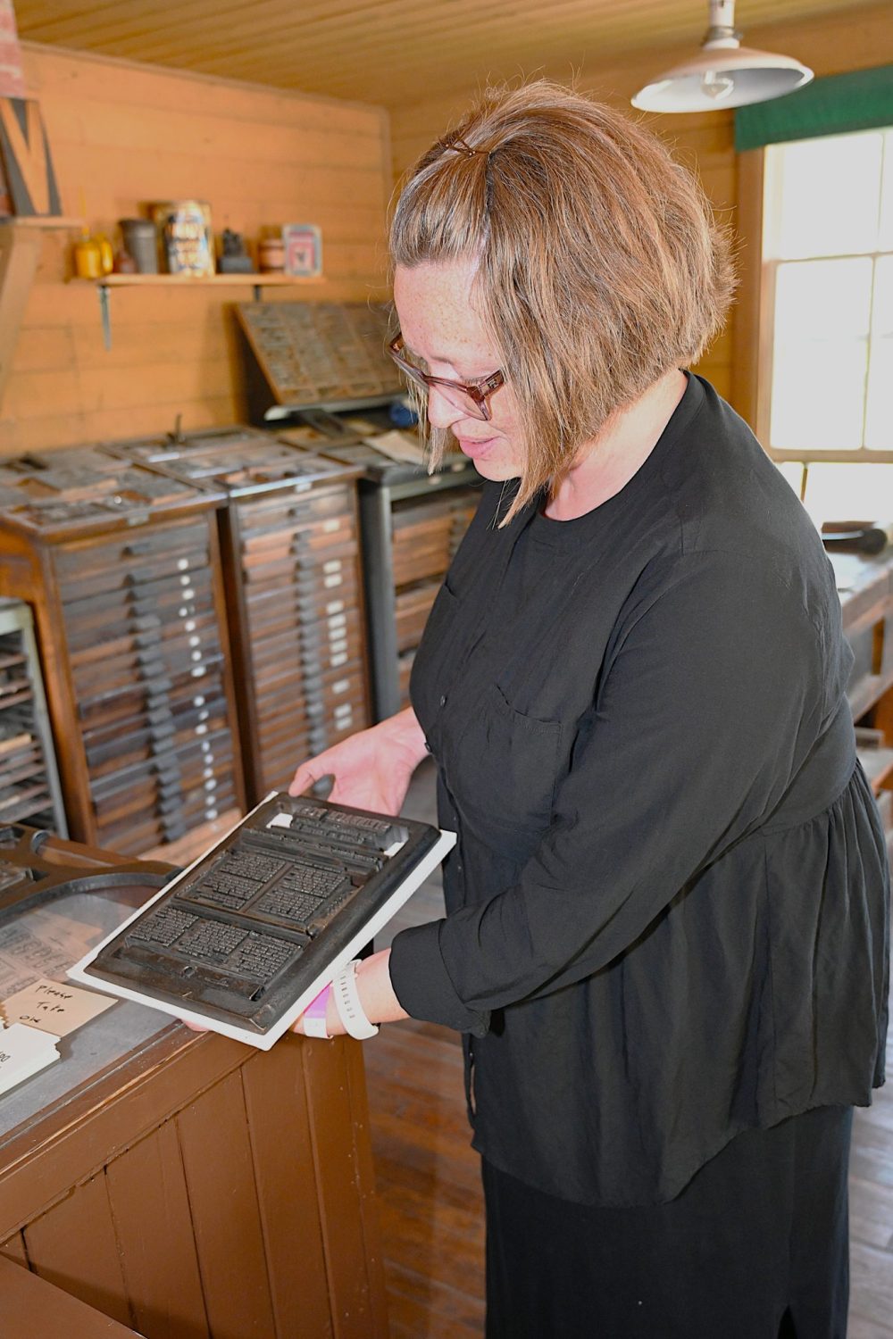 A volunteer displays and demonstrates printing skills in the MHV Printshop.