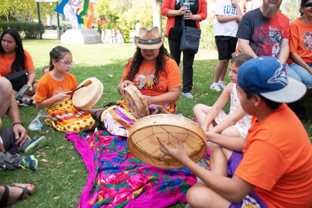 SVJETLANA MLINAREVIC THE CARILLON
Mino Odewin held its Orange Shirt Day Walk on Sept. 30, 2025. It's walk ended at the Steinbach Arts Centre where a drumming circle led by Rayne Ryle who taught the local youth. Learning to drum is Kiarra Graham, Ryle, Solomiia Khuma, and Nev Cheages.