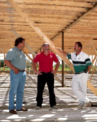 CARILLON ARCHIVES 

Don Janzen and Roger and Curt Loewen have a roof over their heads as the final rafters are being lifted into place by a crane at the first of two Tritek hog barns is nearing completion in the La Broquerie area.