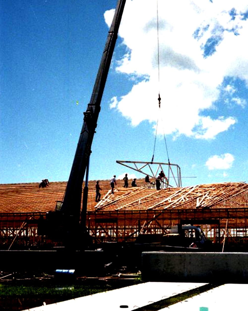 CARILLON ARCHIVES
Carpenters maneuver another huge rafter into place as the crane operator gently lowers it to the top of the walls of the Tritek barn.