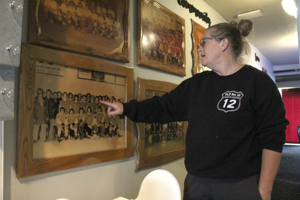 MATTHEW FRANK THE CARILLON
Celeste Plouffe, owner of Ste Anne’s Old No. 12 Cafe & Lounge, points to Ste Anne Aces team members in photos she’s collected. She expects to see a drop in customers for both her restaurant and other businesses because the Aces won’t be playing.