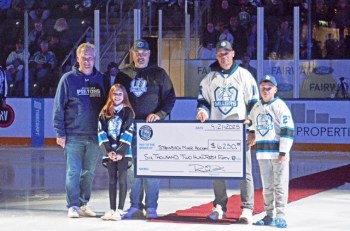 Kent Ledingham (Pistons Board of Directors) presents a cheque to Everly Canada, Ryan Canada, Scott Reimer, and Gavin Reimer from Steinbach Minor Hockey. The Pistons are donating a portion of their 50/50 proceeds inside the Southeast Event Centre to minor hockey as part of a new partnership that includes coaching and complimentary tickets on tournament weekends. (Steinbach Pistons)