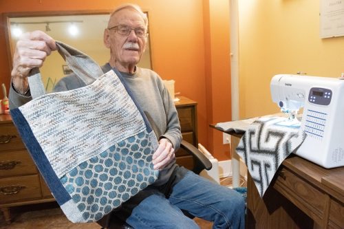 SVJETLANA MLINAREVIC THE CARILLON 

Retired gym teacher Peter Dick sits at his sewing machine in his basement holding a shopping bag he sewed to raise money for South East Helping Hands in Steinbach on Dec. 22.