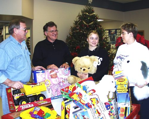 CARILLON ARCHIVES 

Community Christmas Committee chairman Hank Klassen, at left, with Penner Farm Services employees John Kroeker, Trish Richardson and Janet Thoudsanikone display a hamper full of toys to go along with $7,500 in cash donations from employees and owners of the Penner family group of companies.