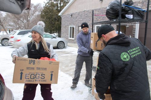 GREG VANDERMEULEN THE CARILLON 

Volunteers load Christmas hampers on Monday in Steinbach.