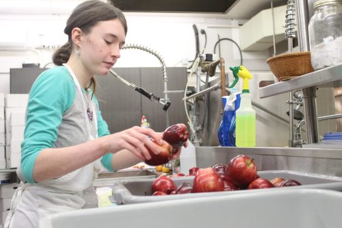 MATTHEW FRANK THE CARILLON 

Heather, 15, washes apples at Soup’s On on Dec. 12. She’s one of the first two youth chosen for The Chrysalis Fund’s youth giving back program.