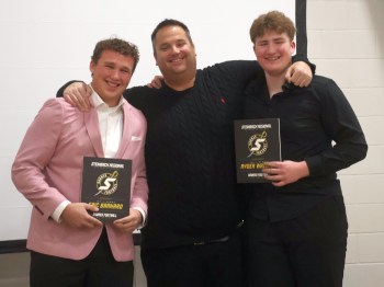 Cassidy Dankochik The Carillon 

Eric Barnard (left) and Ryder Wallace (right) split the varsity top lineman award, presented by head coach Stephan Fedus. The duo picked up other major awards as well at the SRSS Sabres football banquet Dec. 4.