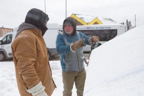 SVJETLANA MLINAREVIC THE CARILLON 

Snow sculptor Lyle Peters talks to his son, Tegegne, on how best to approach their carving of an ambulance on the corner of Archibald Street and Provencher Boulevard in Winnipeg for the Festival du Voyager on Jan. 26, 2026. Peters has been sculpting snow for 40 years.