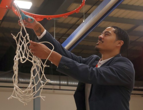 Kendall Perpall cuts down the net following Providence's 69-58 MCAC championship win Feb. 15 at the Niverville CRRC. Perpall is in his first year as head coach of the school's women's basketball program. (Cassidy Dankochik The Carillon)