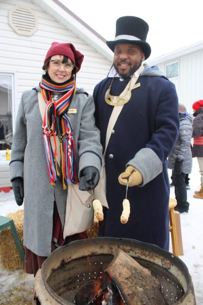 Festival du Voyageur family Brigitte and Ryan Brown roast hotdogs covered in pastry during the event.