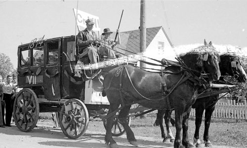 CARILLON ARCHIVES 

With one of his Grade 7 students riding shotgun, teacher John Wittenberg handles the reins for the stage coach, which was one of more than a dozen floats making their way down Main Street, on the way to the fairgrounds for the annual school picnic.