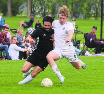 A Grant Park Sporting Club player (white) knocks the ball away from a Niverville Force player during MMSL Division One action at Niverville June 12. (Cassidy Dankochik The Carillon)
