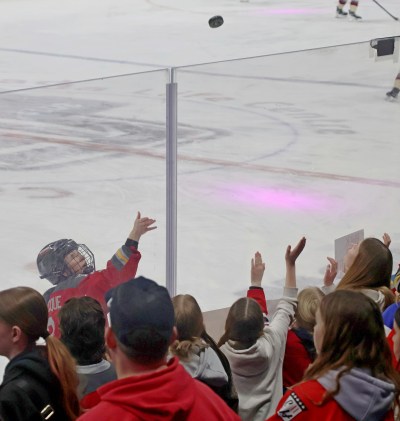 Jocelyne Larocque tosses a puck to some of the hundreds of fans who crowded the boards to watch warm-ups during the PWHL takeover tour game. (Cassidy Dankochik The Carillon)