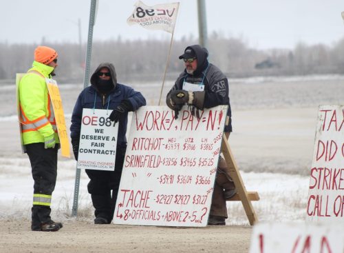 MATTHEW FRANK THE CARILLON 

Operating Engineers of Manitoba Local 987 member and Tache grader operator Matthew Kiazyk (right) stands along the strike picket line in front of the Tache administration office on March 24. He warns that drain clearing isn’t happening which raises flood risks.