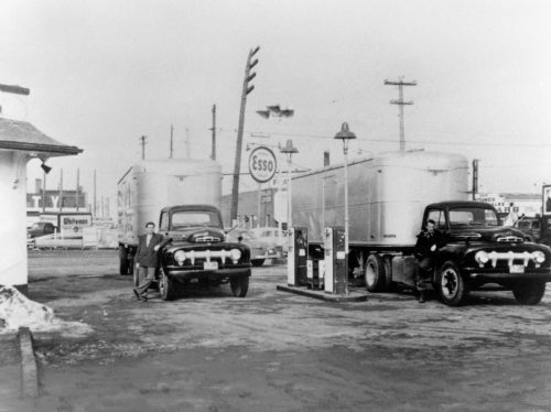CARILLON ARCHIVES 

In this January, 1952 photo, P.K. Penner, at left, and Levi Barkman refuel Penner’s Transfer’s first two tractor-trailer units at the Bill Sweet Service Station in Windsor, Ontario before setting out for home with their very first loads of Ford parts.