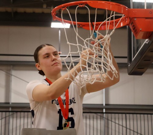 Faith Larocque cuts down the net following Providence's MCAC championship win. Larocque was named the Otterburne-based school's women's athlete of the year. (Cassidy Dankochik Carillon Archives)