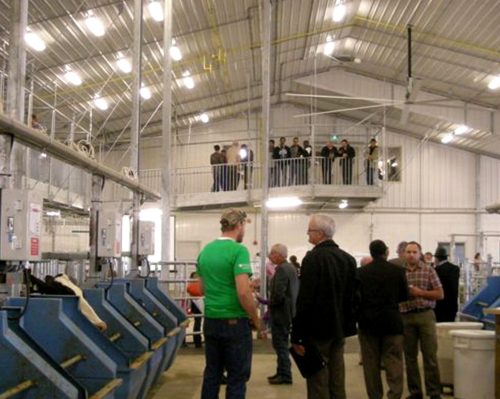 Photo courtesy of Penfor 

A host of dignitaries mingle in the feed aisle getting a close-up look at the computerized feeding station, while another group views the action from a balcony, during an open house at the Rayner Dairy Research centre.